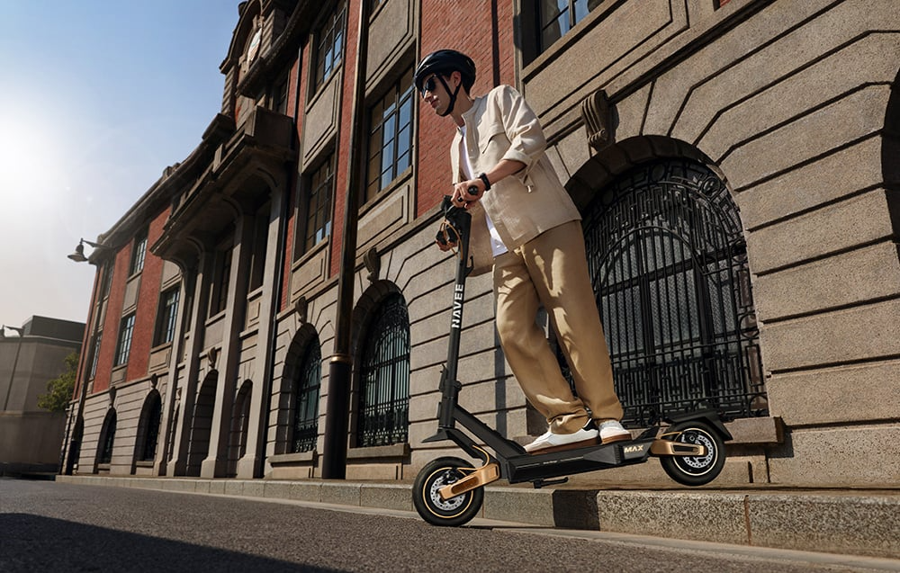 NAVEE ST5 Max z pełnym zawieszeniem Dual Damping Arm podczas zjazdu z krawężnika